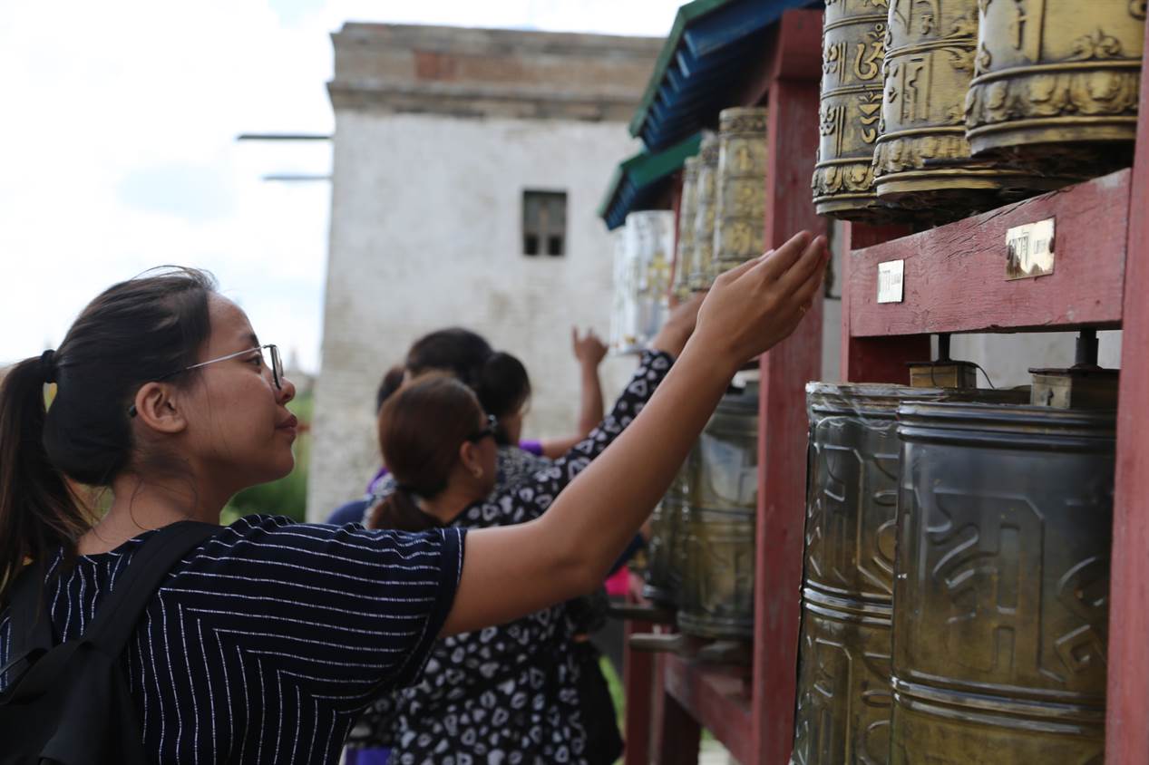 A student spins a prayer wheel at a temple