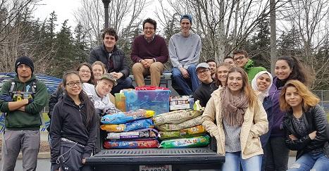 Students pose in the back of a pickup truck filled with donations to the Whatcom Humane Society